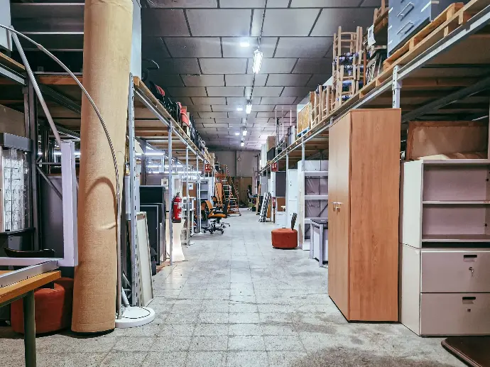 Almacén muebles de oficina de segunda mano Pasillo de nave industrial con exposición de muebles de oficina de segunda mano